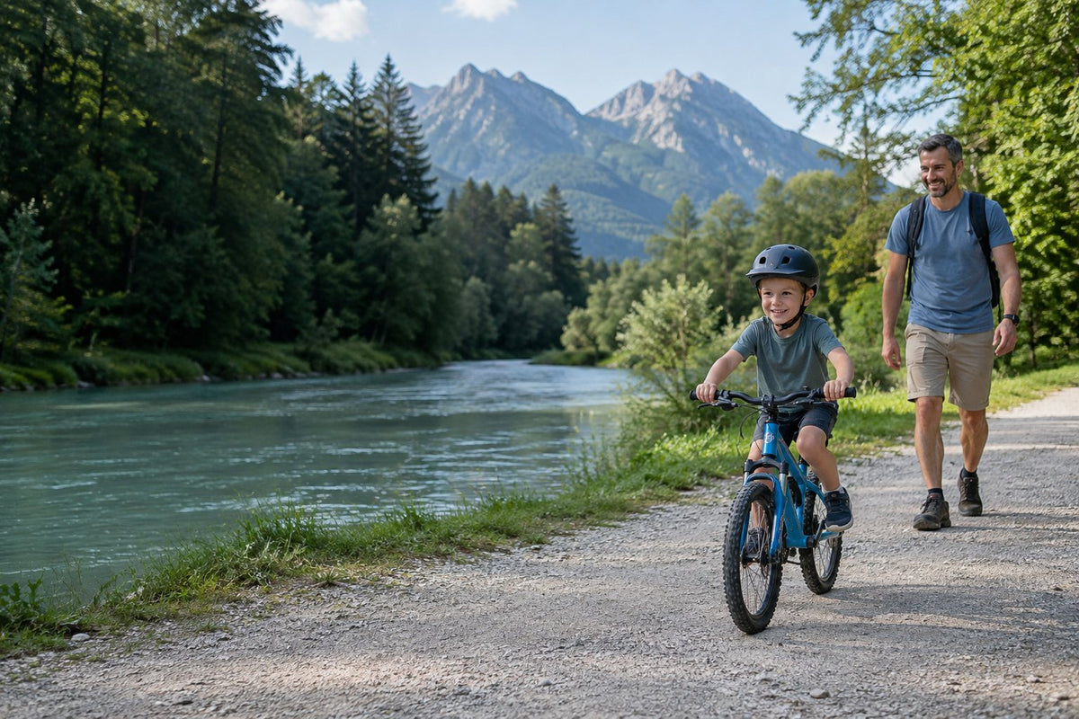 Kind auf Kinderrad mit Vater an einem Flussweg